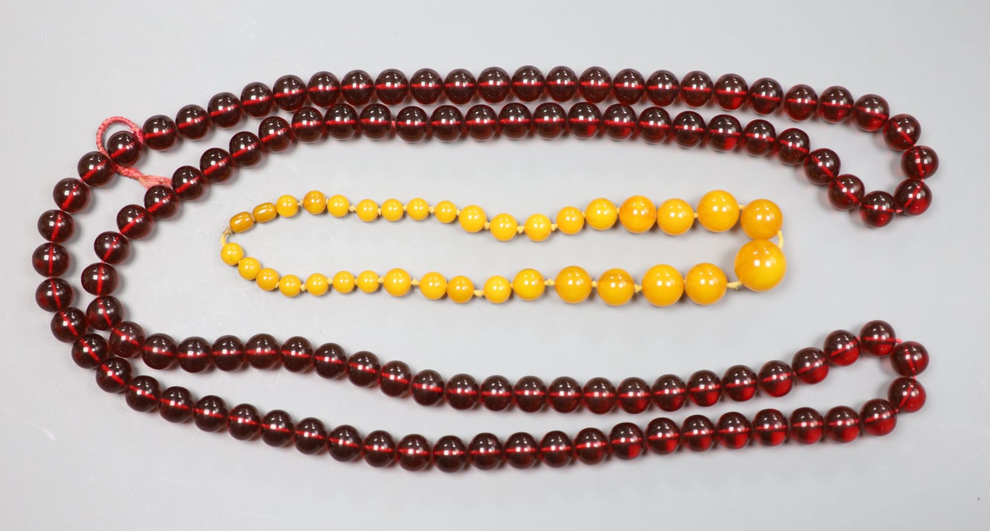 Two faux amber necklaces, 148cm and 44cm.